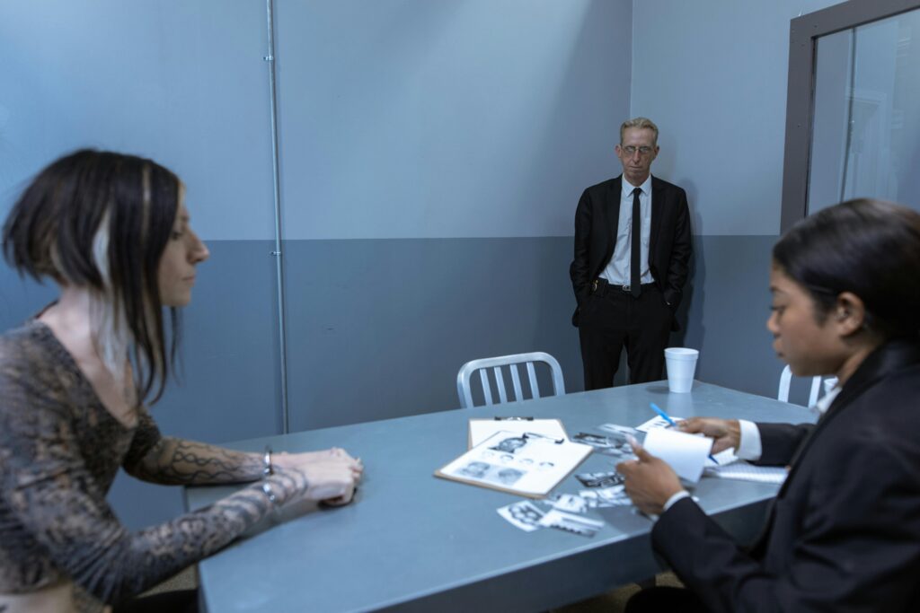 A tense scene in a police interrogation room with officers and a suspect discussing evidence.